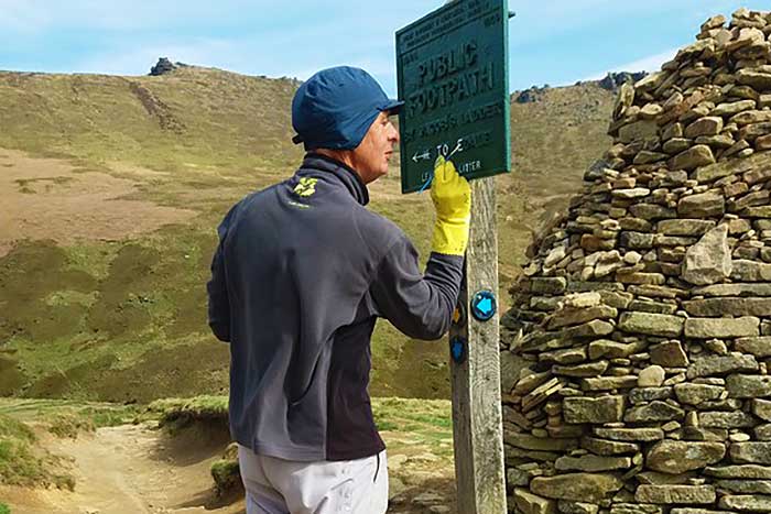 A volunteer repainting one of our cast metal signs