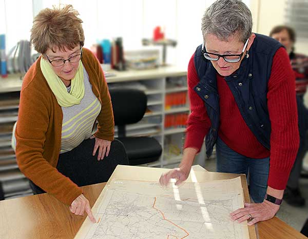 Two volunteers looking closely at a map